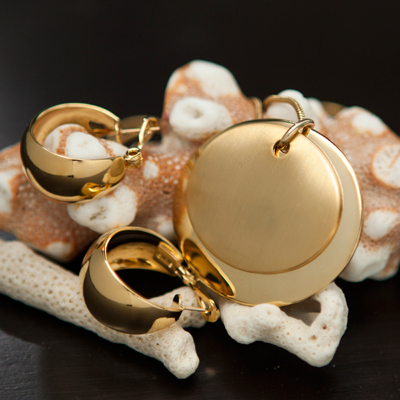 MONET® Gold Disc Pendant and Hoop Earrings - This eye-catching, gold-tone 18" necklace features a double oval charm.  The larger charm has shiny-gold finish and the smaller oval has a matte-gold finish.  Comes with 2-inch extender and coordinating wide-band, circular, shiny gold-tone earrings.